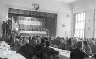 Projev zástupce ministerstva energetiky. Nad pódiem je vyvěšen nápis "Čest budovatelům Lipna". Rok 1959.
