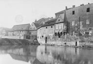 Pohled na zadní části domů čp. 1225 a 1226 na Novém Městě s náspem v místech někdejších Dolních Lodeckých mlýnů. V pozadí Feundův mlýn (dům čp. 1224). Cca před rokem 1910