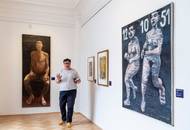 Ředitelka galerie Dana Veselská u obrazu Sedící muž od Rostislava Zárybnického a malby Dvě běžící, kterou vytvořil Jiří Načeradský.
