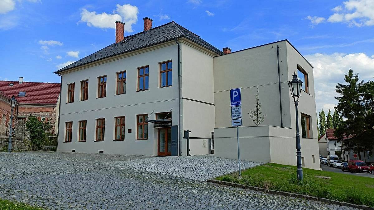 Novojičínská stavební společnost NOSTA, s.r.o., úspěšně dokončila stavební úpravy objektu č. p. 118 na ulici Freudově v Příboře dva měsíce před smluvním termínem. Staveniště bylo předáno 9. června 2023 s plánovaným dokončením během 14 měsíců, avšak díky efektivní organizaci prací byla rekonstrukce hotova již počátkem června 2024.
V průběhu prací byly identifikovány a řešeny problémy, které neovlivnily celkový harmonogram. Stav krovu vyžadoval pouze částečnou sanaci, což umožnilo pokračovat bez zásadních zdržení.
Klíčové stavební úpravy zahrnovaly:
•    Zbudování nových střech a zateplení ploché střechy přístavby, podlahy podkroví a stropu nad schodištěm do sklepa.
•    Opravu fasády v souladu s požadavky památkové péče.
•    Sanační práce včetně injektáže základů.
•    Výměnu všech dveří a oken.
•    Vybudování drenážního systému a vsakovací šachty.
•    Zřízení nového dvorku s centrální klimatizační jednotkou a kontejnery pro administrativní budovu i rodný dům Sigmunda Freuda.
•    Zrušení plynové přípojky a napojení na centrální zásobování teplem.
Interiérové úpravy zahrnovaly:
•    Nové rozvody elektroinstalace, pitné a užitkové vody a kanalizace.
•    Instalaci klimatizace do jižně orientovaných místností.
•    Zřízení rozvodů vzduchotechniky a topení.
•    Dispoziční úpravy sociálních zařízení a kuchyněk.
•    Doplnění podhledů ve všech místnostech kromě skladů.
•    Pokládku koberců v kancelářích a litých podlah v ostatních místnostech.
„Objekt nyní nabízí bezbariérový přístup do obou podlaží díky plošině pro zdravotně handicapované osoby, která je součástí schodiště. K přivolání obsluhy plošiny slouží videotelefon umístěný u hlavního vstupu,“ uvedl Ivo Kunčar z odboru investic, rozvoje a správy majetku.
Do objektu se zpět nastěhují a od 24.06.2024 obnoví činnost odbor stavebního řádu a přestupků, odbor sociální, odbor bytového a nebytového fondu a Pohřební služba st. Agnes.
Budoucí plány zahrnují:
•    Pokračování úprav okolí budovy, včetně opravy chodníku a výsadby zeleně.
•    Potenciální výstavbu cyklopointu financovaného z městského rozpočtu.
Finanční aspekty projektu:
•    Původní smluvní cena byla ve výši 23,3 mil. Kč včetně DPH, konečná cena činila 24,2 mil. Kč včetně DPH.
•    Navýšení ceny o 912 tis. Kč (4 % původní ceny) bylo způsobeno zejména vyrovnáním podlah a sanací štítové zdi.
•    Projekt byl podpořen dotací 9,595 mil. Kč z prostředků státního rozpočtu ČR prostřednictvím Ministerstva pro místní rozvoj.
Závěrem: Odbor investic, rozvoje a správy majetku Městského úřadu Příbor oceňuje spolupráci se společností NOSTA, s.r.o., a věří, že výsledek rekonstrukce přispěje ke spokojenosti veřejnosti. Stavba byla realizována v souladu s požadavky památkové péče a dalšími předpisy týkajícími se veřejných budov.