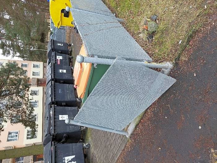 Dobrý den,  poškozený plot u popelnic byl již opraven. Děkujeme za podnět.