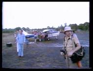 18. listopadu 1978 měla skupina okolo politika Ryana odejít na letiště k připraveným letadlům a vrátit se do USA. Delegaci doplnili i někteří členové sekty, které se z ní rozhodli vystoupit. Díváte se na snímky z autentických videozáběrů, které natočil kameraman NBC Robert Brown. Muž v popředí je fotograf Greg Robinson. V tuto chvíli ještě nikdo netušil, jaká hrůza se za pár minut odehraje.