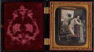 Félix Jacques Moulin: Akt stojící zády k zrcadlu (ručně kolorovaná daguerrotypie v původním rámování, 1851–1853). Ze sbírek Muzea J. Paula Gettyho v Los Angeles.