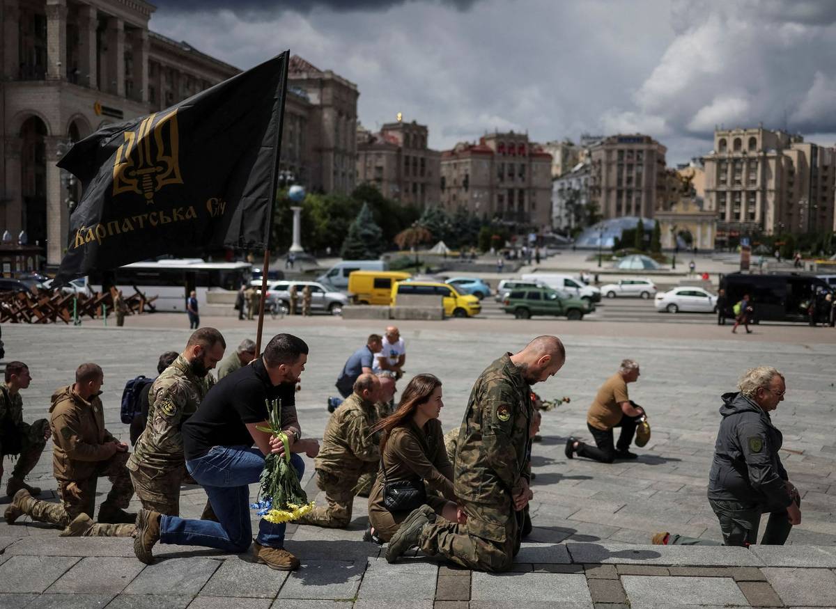 Vojáci a vojačky vzdávají hold padlému veliteli na náměstí Nezávislosti s praporem Karpatské Síče.