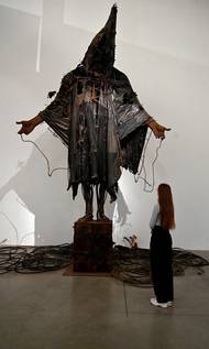 Socha Casting a Dark Democracy od Tima Shawa parafrázuje fotografii Američany mučeného vězně v iráckém žaláři Abú Ghrajb, která byla zveřejněna roku 2004.