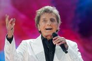 Krátce po půl osmé večer, zatímco zpíval Barry Manilow (na fotce), koncert zastavil blesk. "Prosím, najděte si bezpečné místo a schovejte se," zaznělo z reproduktorů místo hudby a davy lidí začaly park opouštět.
