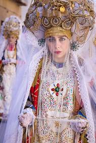 Postava Veroniky se služebnicemi se v průvodu objevila až v době španělské nadvlády na Sicílii. Podle legendy Veronika cestou na Golgotu podala Ježíši potní šátek aby si otřel tvář. Kristův obraz se tak zázračně otiskl do roušky, kterou pak sv. Veronika v Římě předala sv. Klementu Římskému.