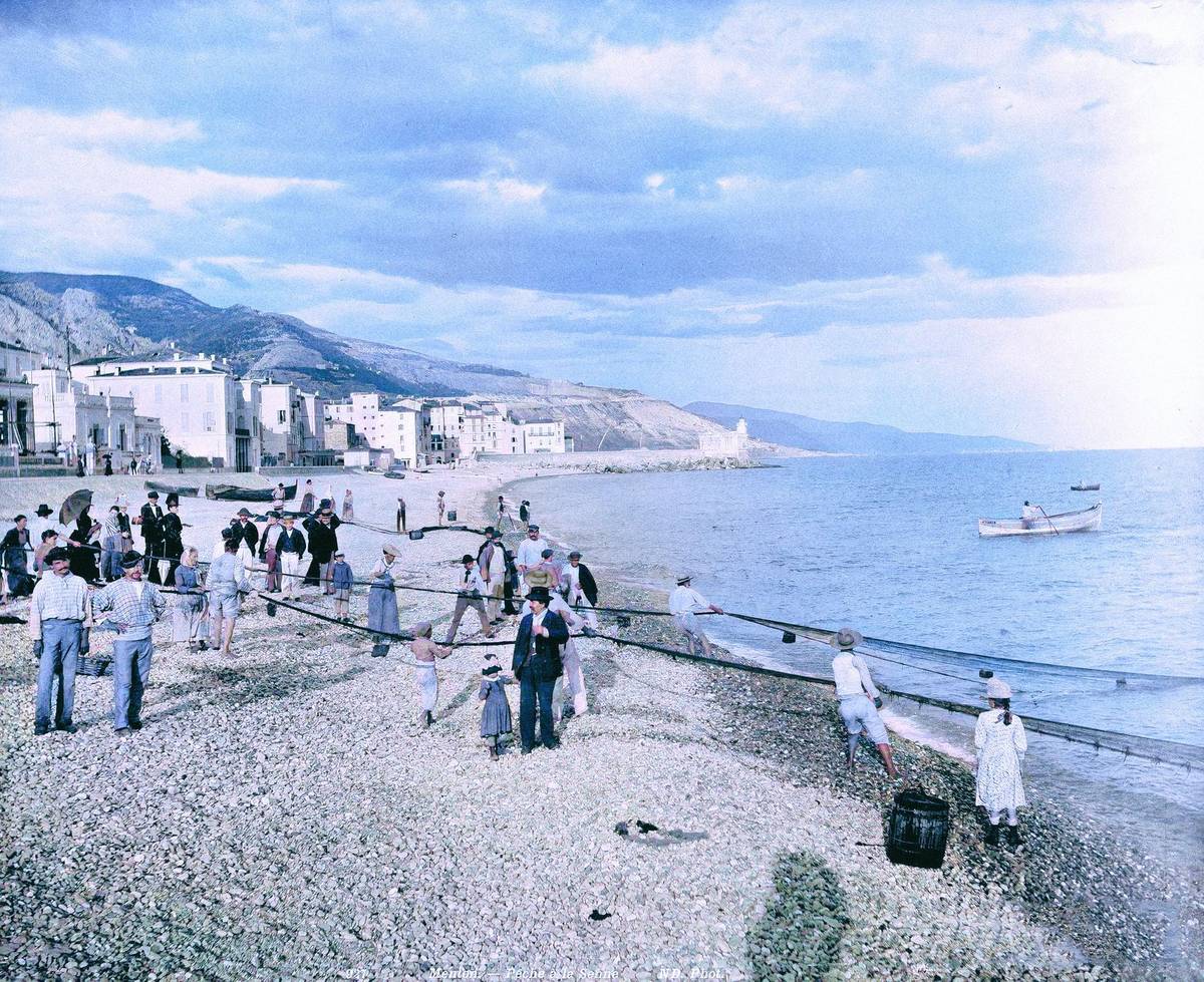 Plavky byly výrazně delší a méně barevné. Na procházky po pláži se chodilo v sukních až po zem nebo v obleku s buřinkou. Ale jinak se toho v nejrůznějších letoviscích za posledních 100 let zas až tolik nezměnilo. Pláže byly a jsou plné lidí, kteří si užívají léta, slunce a vody. Připomeňte si zašlé časy na jedinečných historických snímcích, které koloroval fotoeditor Aktuálně.cz Daniel Poláček. Na tomto snímku jsou zachyceni rybáři v jihofrancouzském Mentonu (kolem roku 1900).