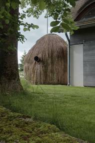 Navrhli ji ve znamení tradice, jako kupku sena. Co suchá tráva skrývá uvnitř, prozrazují jen některé detaily, jako je výduch z kamen.