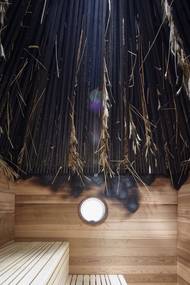 Zatímco zvenku stavba působí všedně, uvnitř ji tvoří kuželovitý převýšený prostor se stropem z opálených latěk.