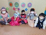 Děti na sobě mají korejský kroj. V Jižní Koreji se mu říká hanbok.