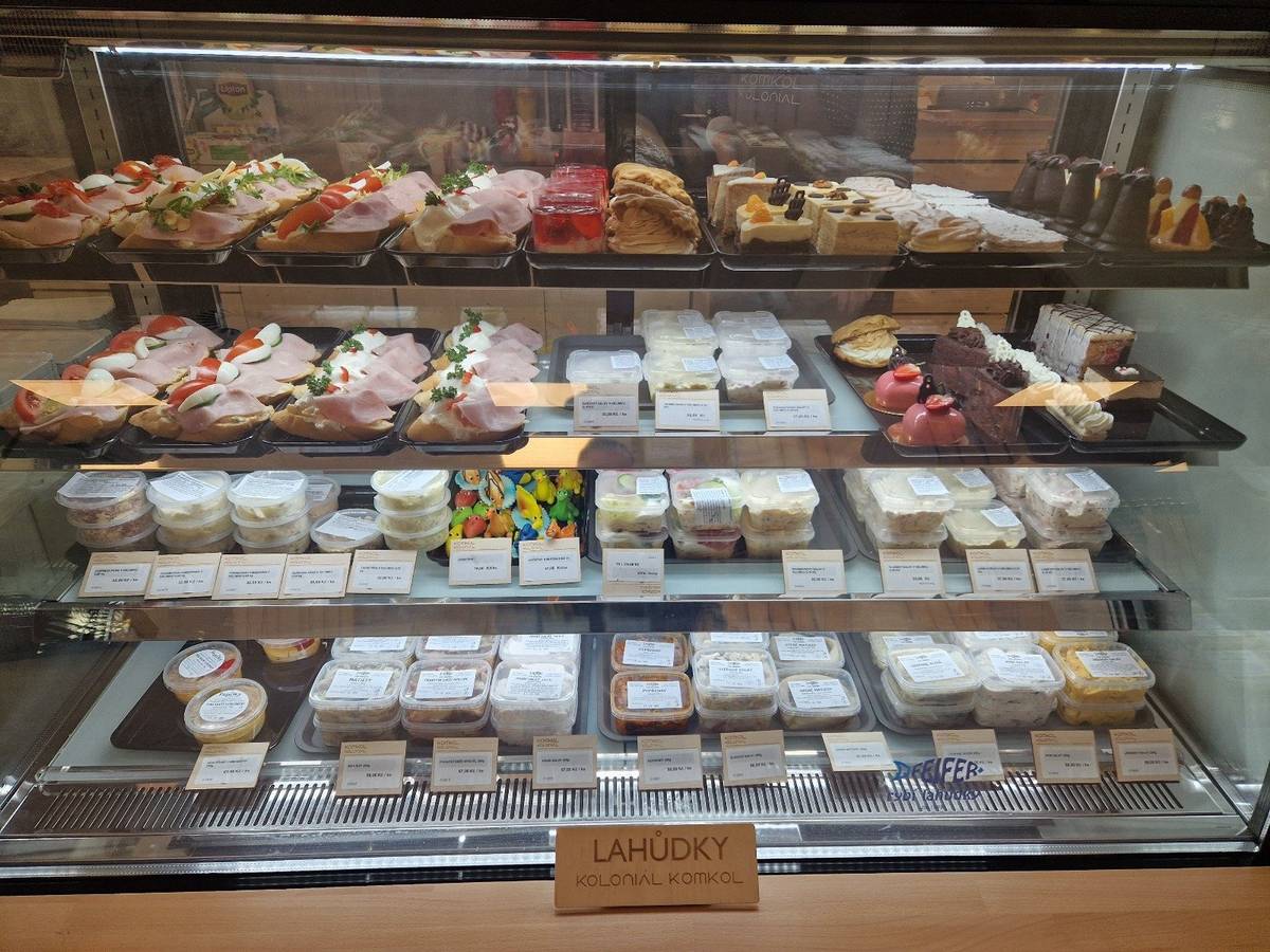 Milí sousedé, každý den čerstvé chlebíčky, saláty, pomazánky z Larsu, zákusky od Buchalů a rybí lahůdky od Feifera. Naše cukrářská vitrína - seznamte se, prosím. Váš KomKol