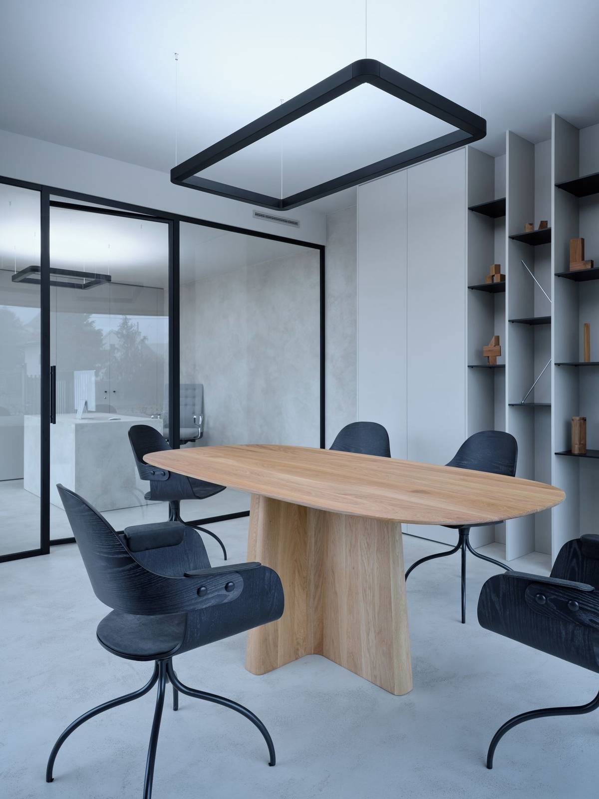 Ve společných prostorách administrativy tvoří kombinace dřevěných prvků s monochromatickou stěrkou elegantní celek.