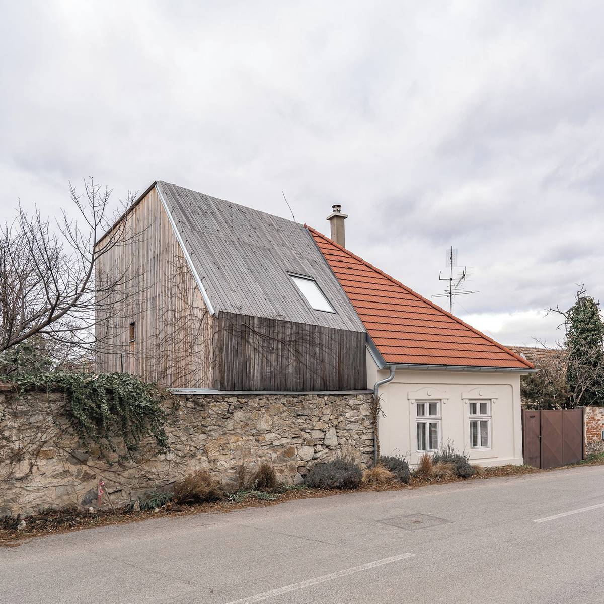 Ve venkovní části nové přístavby dominuje dřevo, u kterého tvůrci záměrně nepoužili viditelnou povrchovou úpravu, aby se čas a vliv prostředí na materiálu začal propisovat. Stavba tak získává o to větší charakter a příběh.