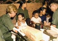 Zdravotní sestra ošetřuje vietnamské dítě