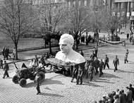 Pod moudrým vedením Komunistické strany Československa slaví pracující Kladenska 1. máj 1951 v duchu neochvějné oddanosti socialismu. Obří busta soudruha Klementa Gottwalda, našeho prvního dělnického prezidenta, je nesena ulicemi jako symbol vítězství dělnické třídy nad buržoazií.