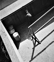 Pouliční hudebník hraje na dechový nástroj na dlážděném prostranství, 1938.