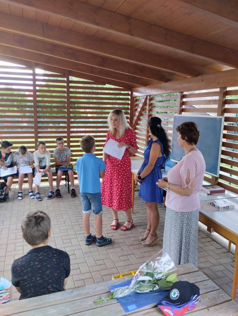 Slavnostní předání vysvědčení na školní zahradě.