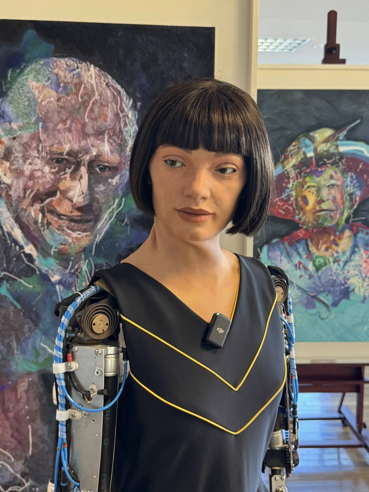 Ai-Da před portréty Alžběty II. a Karla III.