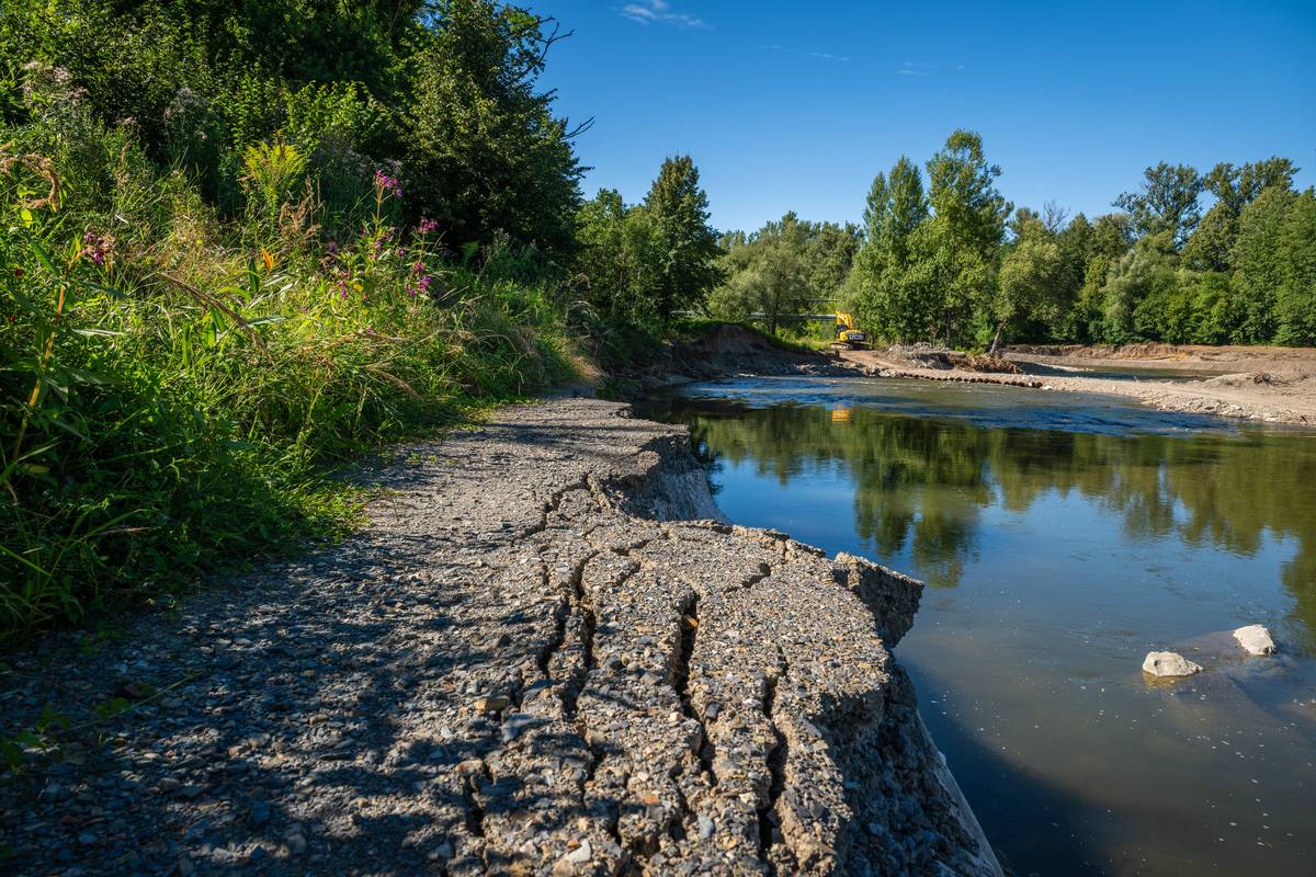 V důsledku zvýšených průtoků řeky Olše na konci července došlo v Karviné k poškození části cyklostezky v lokalitě nedaleko rekonstruovaného jezu Karviné-Ráji. Během dvou dnů tady dosahoval průtok řeky hodnoty až 110 m³/s, což způsobilo rozlití vody mimo koryto. Proudící voda poškodila nejen rozestavěné části nového obtoku, ale také zasáhla přilehlou cyklostezku, která je v majetku města Karviné. „Vzhledem k tomu, že samotná stavba byla v době události před dokončením a pracovalo se na úpravách obtoku, došlo ke stržení části provizorního opevnění. Voda se tak dostala do míst, která měla zůstat mimo zásah. Situaci řešíme s dodavatelem stavby i městem a podnikáme kroky k nápravě,“ uvedla mluvčí Povodí Odry Šárka Vlčková. Aktuálně probíhá geodetické zaměření škod, které bude podkladem pro návrh harmonogramu oprav. „Do doby zpracování výstupu (nejpozději do 15. srpna) nelze stanovit přesný termín zahájení oprav. Přesto už je nyní jasné, že práce budou rozsáhlé – v místě bude potřeba dosypat a hutnit zeminu až do výšky 7–8 metrů, s důrazem na její kvalitní konsolidaci, aby se předešlo sesedání,“ doplnila Vlčková. Společně s Povodím Odry hledá Karviná i dočasné řešení, které by cyklistům umožnilo bezpečný průjezd po dobu oprav. „Chápeme, že je to nepříjemná situace pro všechny, kdo cyklostezku využívají. Přesto je potřeba udělat opravy důkladně a technicky správně. Pokud by se nedodržel správný postup, hrozilo by popraskání nového povrchu. I proto bude v první fázi položena provizorní vozovka ze štěrkodrti, kterou na jaře příštího roku nahradí finální asfaltový povrch,“ říká vedoucí Odboru komunálních služeb karvinského magistrátu Jana Maierová. Předpokládá se, že práce budou zahájeny v září a potrvají přibližně dva měsíce. Vzhledem k nutným administrativním krokům, například vyjednání náhradní trasy cyklostezky přes zalesněné pozemky, odhaduje město i Povodí Odry dokončení oprav nejdříve koncem roku. O vývoji vás budeme průběžně informovat.