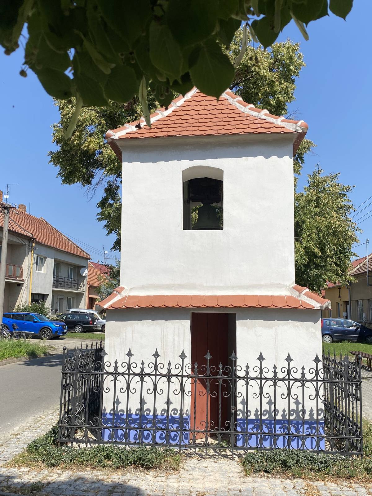 Historická zvonice v Milokošti prochází rozsáhlou rekonstrukcí. Po opravě střechy budou následovat dokončovací práce včetně vyčištění, nových nátěrů a úprav okolí. Památka v ulici V Dědině tak získá nový vzhled a opět bude ozdobou této části města. V místní části Veselí nad Moravou – Milokošti – právě probíhá oprava tamní historické zvonice v ulici V Dědině. Stavba, která už více než tři století patří k výrazným dominantám této části města, se dočká nejen nové střechy, ale i dalších důkladných úprav. Podnět k opravě přišel od Osadního výboru Milokošť, který upozornil město na havarijní stav objektu. Veselí nad Moravou následně vypsalo výběrové řízení, díky kterému se podařilo cenu rekonstrukce střechy snížit na 150 tisíc korun. Opravu střechy a klenby provádí odborná firma STAK – D z Domanína. Zvonice stojí v Milokošti od roku 1715. Tehdejší obyvatelé ji nechali postavit jako výraz vděku za přežití válek a morových ran. Její současná podoba pochází z poloviny 19. století a od roku 1958 je chráněna jako kulturní památka. Zajímavostí je neobvyklá konstrukce střechy – tašky nejsou uloženy na dřevěných latích, ale přímo na vyzděné klenbě. Právě proto se musí i dnes jednotlivé kusy krytiny na klenbu lepit, což práci znesnadňuje. Po dokončení střechy se od poloviny srpna do oprav zapojily Služby Města Veselí, které zajistí důkladné vyčištění objektu, nový nátěr fasády a soklu, údržbu kovových částí, opravu či výměnu dřevěných prvků, obnovu oltářního prostoru a také úklid okolí zvonice. Pokud vše půjde podle plánu, už na začátku října se Milokošť dočká zvonice v novém hávu – tak, aby opět důstojně stála V Dědině, kde po staletí připomíná historii i odolnost zdejších obyvatel.