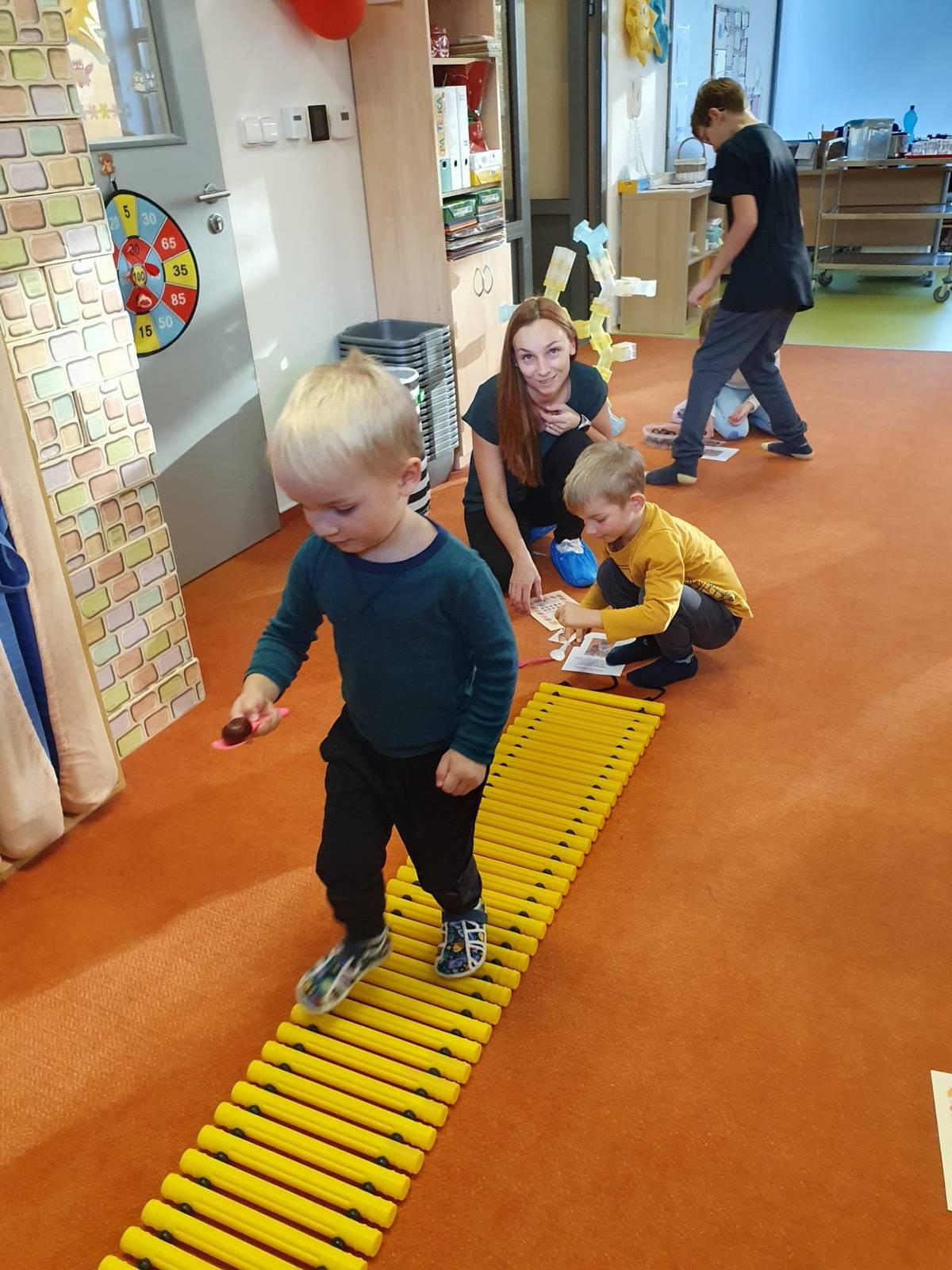 V říjnu jsme ve třídě Zvoneček v MŠ Janáčkova prožili krásné odpoledne plné her, smíchu a podzimní pohody. Uspořádali jsme naši první společnou akci s rodiči – Kaštánkohraní. Protože všechny děti letos do školky nastoupily poprvé, byla to pro nás všechny výjimečná příležitost se lépe poznat a užít si společný čas.   Děti po příchodu dostaly motivační kartičku se vzkazem od skřítka Kaštánka, na kterou sbíraly razítka za splněné úkoly. Společně s rodiči se pak vydaly na cestu za dobrodružstvím, kde je čekalo 21 stanovišť zaměřených na senzomotoriku, jemnou motoriku, prostorovou představivost, zrakové vnímání, koordinaci, logické myšlení a koncentraci.       Za každý splněný úkol děti získaly razítko od svých rodičů, kteří je s nadšením podporovali a povzbuzovali. 🎲🎯   Úkolem bylo splnit alespoň 10 stanovišť, a kdo to dokázal, mohl se těšit na malou odměnu od skřítka Kaštánka – Kouzelný kaštánek pro štěstí, diplom, omalovánku a sladké lízátko. 🌰       Celé odpoledne se neslo v duchu radosti, spolupráce a podzimní fantazie. Rodiče se svým dětem aktivně věnovali, pomáhali jim plnit úkoly a přinesli i spoustu dobrot, které přispěly k příjemné a přátelské atmosféře.   Cílem akce bylo, aby si děti i rodiče odnesli radostný zážitek, pocit sounáležitosti a společně strávený čas, který v dětech zanechá hezkou vzpomínku na jejich první podzim ve školce. 👨👩👧👦       Děkujeme všem, kteří se zapojili, a těšíme se na další společná setkání!   Více fotek na Facebooku: Město Frýdlant nad Ostravicí