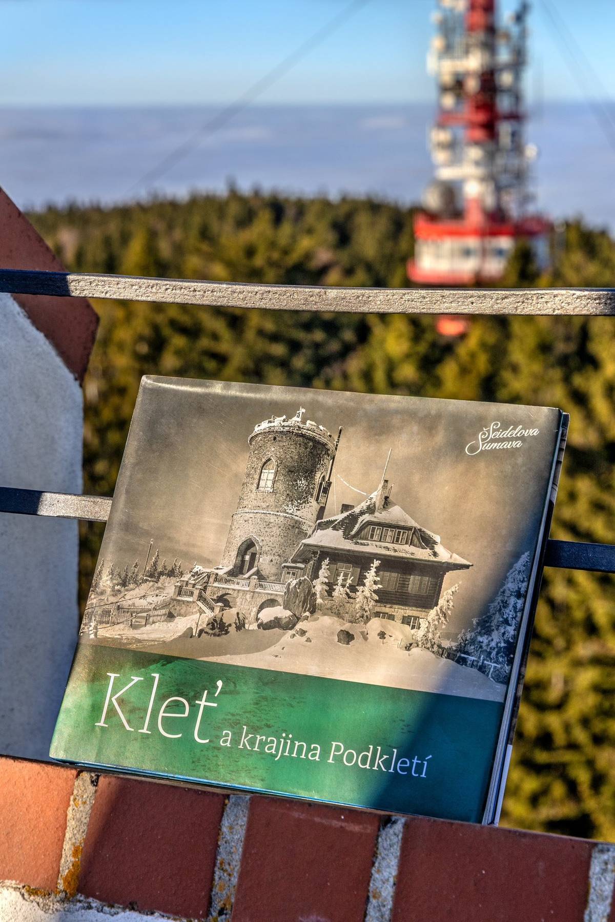 Ve čtvrtek 11. prosince 2025 byla pokřtěna pátá publikace z edice Seidelova Šumava – Kleť a krajina Podkletí. Novinka vydaná Českokrumlovským rozvojovým fondem, spol. s r. o. – Museem Fotoateliér Seidel, navazuje formátem i obsahem na předchozí svazky z let 2016–2022: Lipno – krajina pod hladinou, Šumava – krajina pod sněhem, Krumlov – město pod věží a Boleticko – krajina zapomenuté Šumavy. Kniha vychází v roce významných výročí – 200 let od vzniku Josefovy věže, nejstarší kamenné rozhledny v Čechách, a 100 let od postavení Tereziiny chaty na vrcholu Kleti. Rok 2025 je zároveň 20. rokem realizace projektu Museum Fotoateliér Seidel a připomíná i 120 let od otevření původního fotoateliéru v Linecké ulici. „Jednotlivé kapitoly knihy provedou čtenáře od vrcholu Kleti a jižních svahů kleťského masivu přes Zrcadlovou Huť, Zlatou Korunu, Holubov, Křemži, Brloh a Janské Údolí až po vzdálené Strýčicko,“ představuje Zdena Mrázková, jedna z autorek knihy. Na knize se dále podíleli autoři Jindřich Špinar, Petr Hudičák, Jiří Bárta a tým spolupracovníků spojených s Fotoateliérem Seidel – Jan Lakosil, Luděk Němec, Raimund Paleczek a Markéta Tanzerová. Publikaci obohatily také další osobnosti a instituce, jejichž přínos výrazně formoval její výslednou podobu. Unikátní historické snímky Josefa a Františka Seidelových, Josefa Wolfa, ale i dalších méně známých, ovšem rovněž mimořádných fotografů – Antonína Bednáře, Jana Wagnera či Jaroslava Tkadlece zachycují kraj od vrcholku Kleti po její široké okolí. Další fotografie pocházejí z partnerských institucí (Regionální muzeum v Českém Krumlově, Jihočeské muzeum v Českých Budějovicích, Státní oblastní archiv v Třeboni, oddělení Český Krumlov, Státní oblastní archiv v Třeboni, Státní okresní archiv Český Krumlov) i ze soukromých sbírek. Zastoupeny jsou i snímky z Muzea Šumavy ve Vídni, které dlouhodobě spolupracuje s Museem Fotoateliér Seidel a aktuálně také v rámci projektu Interreg Rakousko – Česko. „Srdcem jsem Kleťák. Chodím na Kleť tak často, jak mi to povinnosti dovolí, a pokaždé tam nacházím kus klidu i inspirace. I proto mám velkou radost, že právě této hoře je věnován další svazek Seidelovy edice. Je to kniha, která s úctou zachycuje krajinu, již máme tolik rádi, a zároveň připomíná její příběhy i lidi, kteří ji po generace formovali,“ říká starosta Alexandr Nogrády, který převzal nad knihou záštitu a zároveň se stane jejím kmotrem. Fotografická část knihy nabízí výhledy z Kleti i pohledy na horu z jejího podhůří, přibližuje její historii a přináší příběhy lidí, kteří tu žili po staletí. Historické záběry doplňují současné fotografie Kláry Sváčkové, Libora Sváčka, Kristiny Zavaly a Lenky Štěpánkové. Grafické zpracování celé edice, včetně této novinky, připravil vydavatel Tomáš Halama. Kniha bude v prodeji 16. 12. 2025 v Regionálním muzeu v Českém Krumlově v rámci veřejné prezentace a od 17. 12. 2025 v Museu Fotoateliér Seidel, Infocentru Český Krumlov, knihkupectvích Expedice Český Krumlov a Kanzelsberger České Budějovice a v online distribuci KOSMAS.