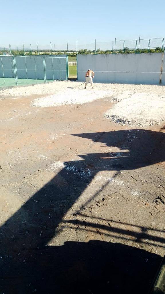 Zaměstnanci obce přetvářejí staré nevyužívané hřiště na pískové hřiště na beach fotbal.