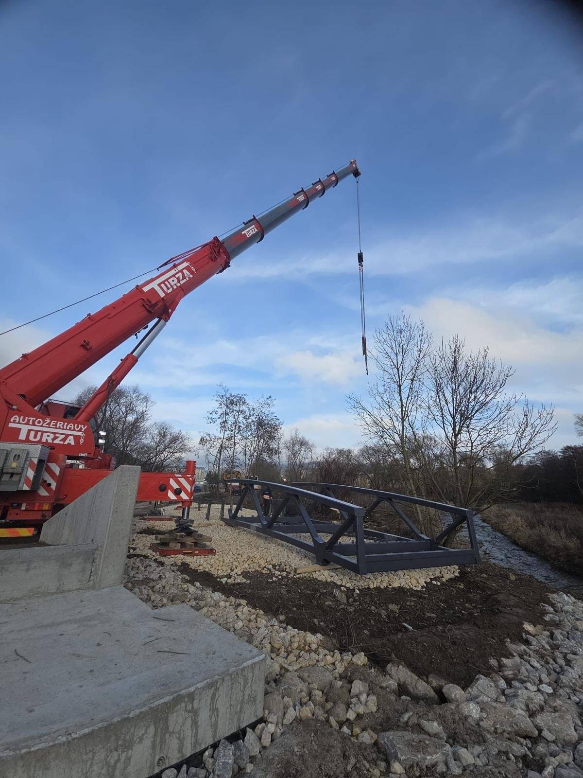 V utorok 16.12.2025 k nám postupne dorazili tri diely cyklomosta, ktorého výrobu zastrešila spoločnosť Cb-mont, s.r.o...    V priebehu 7. týždňov zostrojili konštrukciu s dĺžkou 26,7 m a váhou 21 800 kg...     V nasledujúcich dňoch budú realizované práce, aby sa lávka stala prechodnou...