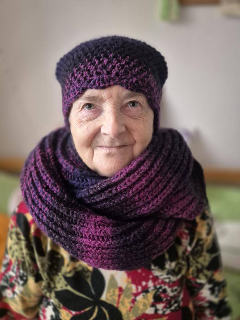 Představujeme vám naši klientku, paní Vlastu Juráškovou (85 let). Pletení a háčkování je jejím celoživotním koníčkem. Na fotografii nám zapózovala jako model v čepici a šále, které sama upletla.