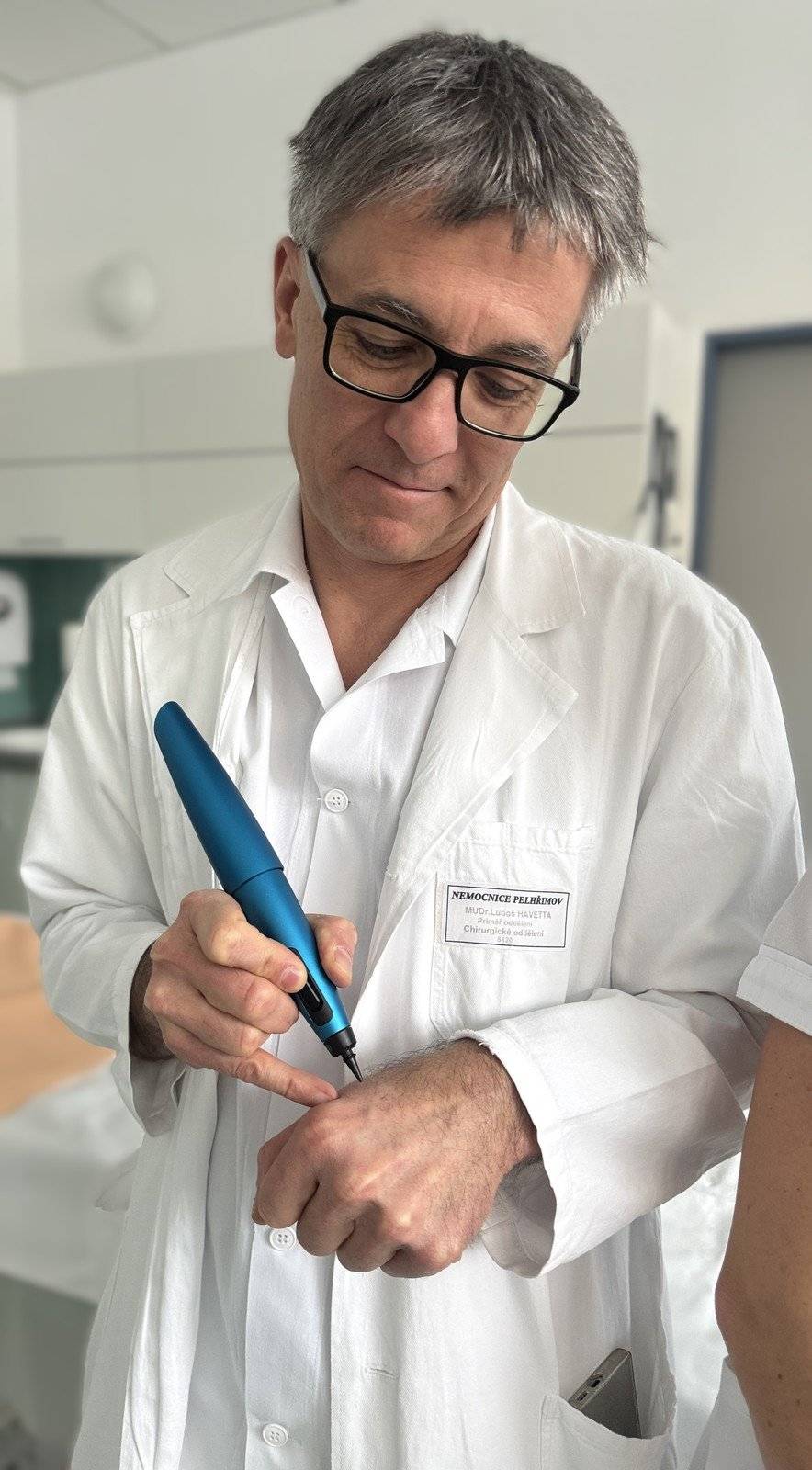 Nemocnice Pelhřimov rozšiřuje nabídku ambulantních výkonů o moderní kryochirurgickou metodu CryoPen. Ta umožňuje rychlé, přesné a šetrné odstranění různých nezhoubných kožních výrůstků, bradavic, polypů či dalších drobných lézí, které mohou pacientům působit zdravotní nebo estetické obtíže. Výhodou je minimální bolestivost zákroku, nízké riziko komplikací a velmi dobrý kosmetický efekt. Nový přístroj lékaři využívají v chirurgické, urologické a gynekologické ambulanci.   CryoPen je moderní ruční kryochirurgický nástroj, který pracuje na principu cíleného zmražení postižené tkáně. Lékař při výkonu přesně aplikuje mikroskopický proud oxidu dusného přímo na ošetřované místo. V místě aplikace dochází k prudkému poklesu teploty, což vede k odumření nežádoucí tkáně, zatímco okolní zdravá tkáň zůstává maximálně šetřena. Díky vysoké přesnosti je metoda vhodná i pro ošetření drobných lézí v anatomicky citlivých lokalitách.   Výkon probíhá ambulantně, zpravidla bez nutnosti anestezie a trvá několik sekund. Ve většině případů není potřeba žádná speciální následná péče a pacient se může ihned vrátit k běžným aktivitám. Podle charakteru a velikosti léze může být ošetření provedeno při jedné či více návštěvách. „Naší dlouhodobou prioritou je přinášet pacientům moderní metody, které zvyšují komfort léčby a zároveň splňují nejvyšší odborné standardy. CryoPen je technologií, která umožňuje velmi šetrné ošetření bez zbytečné zátěže pro pacienta a bez nutnosti hospitalizace,“ uvedl ředitel Nemocnice Pelhřimov Radim Hošek. Ošetření metodou CryoPen je poskytováno za přímou úhradu ve výši 500 korun. „Nemocnice pořídila dva přístroje CryoPen v celkové hodnotě bezmála 228 tisíc korun. Investice do této technologie je součástí systematické modernizace ambulantních provozů a rozšiřování spektra výkonů, které jsme schopni pacientům nabídnout,“ doplnil technický náměstek nemocnice Petr Adam.   CryoPen lékaři využívají napříč několika odbornostmi, což umožňuje lepší dostupnost této metody a plynulou návaznost péče. Zavedením nové technologie Nemocnice Pelhřimov potvrzuje svůj důraz na moderní, dostupnou a pacientsky vstřícnou zdravotní péči. TZ: Nemocnice Pelhřimov