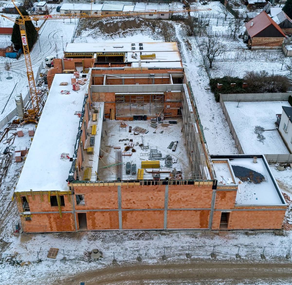 V souvislosti s výstavbou nového Obecního domu se našemu městu podařilo získat už třetí dotaci v řadě! Bilance je tedy jasná a radostná zároveň: tři podané žádosti = tři získané dotace. Nejnovější finanční podpora je z Ministerstva pro místní rozvoj, konkrétně z Integrovaného regionálního operačního programu, a to ve výši 7.963.703 Kč.  Celkově se nám tak na projekt Obecního domu podařilo získat už téměř 38 milionů korun a o další dotace budeme žádat! Přestože počasí stavebním pracím v posledních týdnech příliš nepřeje, stavba pokračuje podle stanoveného harmonogramu. Nový Obecní dům tak doslova roste před očima a brzy se stane moderním kulturním a společenským centrem našeho města.  Na jednom místě nabídne kvalitní zázemí pro: městskou knihovnu, informační centrum, základní uměleckou školu s moderními akustickými učebnami a menším koncertním sálem, velký multifunkční sál s kapacitou 527 míst, určený pro široké spektrum kulturních a společenských akcí (pro srovnání – oficiální kapacita sokolovny je 462 míst).  Projekt v hodnotě téměř 166 milionů Kč bez DPH realizuje společnost MSO servis spol. s r. o. Kyjov. Dokončení stavby je plánováno do 600 kalendářních dnů od zahájení prací v červnu loňského roku. Nový Obecní dům se tak již brzy stane novým srdcem Vracova – místem pro vzdělávání, kulturu i společenská setkávání.  Podívat se na vizualizaci Obecního domu můžete na https://youtu.be/oaZfkYqKkVs