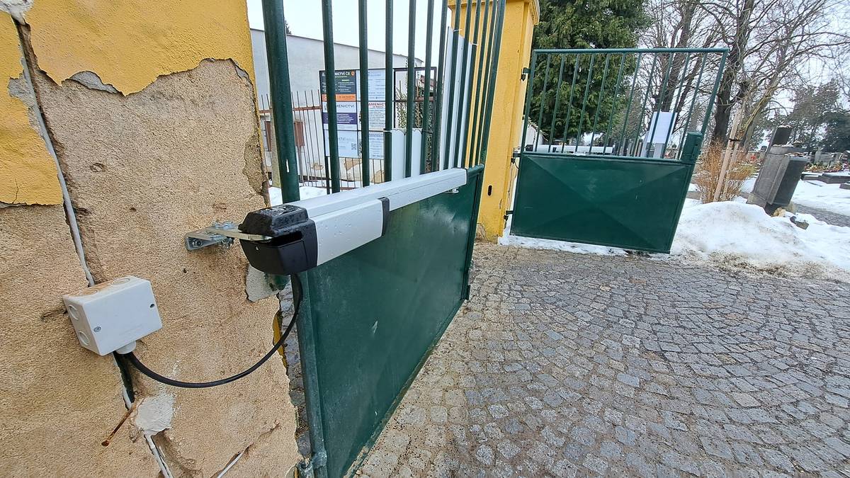 Nový rok s sebou přinesl jednu novinku na Městském hřbitově v Litoměřicích. Obě vchodové brány se nyní zavírají elektronicky na dálku ze sídla Technických služeb města (TSM). Důvodem je legislativní změna a úspora.  „Pracovníci na „dohodu“ mají od loňského roku nárok na dovolenou stejně jako řadoví zaměstnanci. Z tohoto důvodu museli naši pohotovostní pracovníci jezdit v době nepřítomnosti „dohodáře“ hřbitov zamykat a o víkendech i odemykat,“ vysvětlil Petr Kurc, provozní ředitel TSM Litoměřice. V prosinci bylo proto na brány nainstalováno elektronické zařízení, díky němuž se nyní otevírají a zavírají na dálku. „Ve všední dny ráno areál odemykají pracovníci hřbitova,“ upřesnil Petr Kurc. Na branách jsou vyvěšeny instrukce pro ty, kteří by se na hřbitově „zapomněli“ i po zavírací době. „Dotyčný může jednoduše zavolat na telefonní číslo uvedené na letáku a recepční u nás v areálu bránu otevře. Pokud by telefon neměl, stačí poodstoupit pár metrů od brány a díky kamerovému systému ho náš pracovník uvidí a do několika minut vypustí ven,“ doplnil Petr Kurc. Hřbitov je nyní v provozu dle zimní otevírací doby (od 1. 11. do 31. 3.) od 8 do 18 hodin. Letní provoz (1. 4. – 31. 10.) je pak od 7 do 20 hodin. „Za první týdny provozu elektronického zamykání bran se zatím v areálu nikdo nezdržel,“ uzavřel Petr Kurc. {gallery}/02026/hrbitov_otevirani{/gallery}