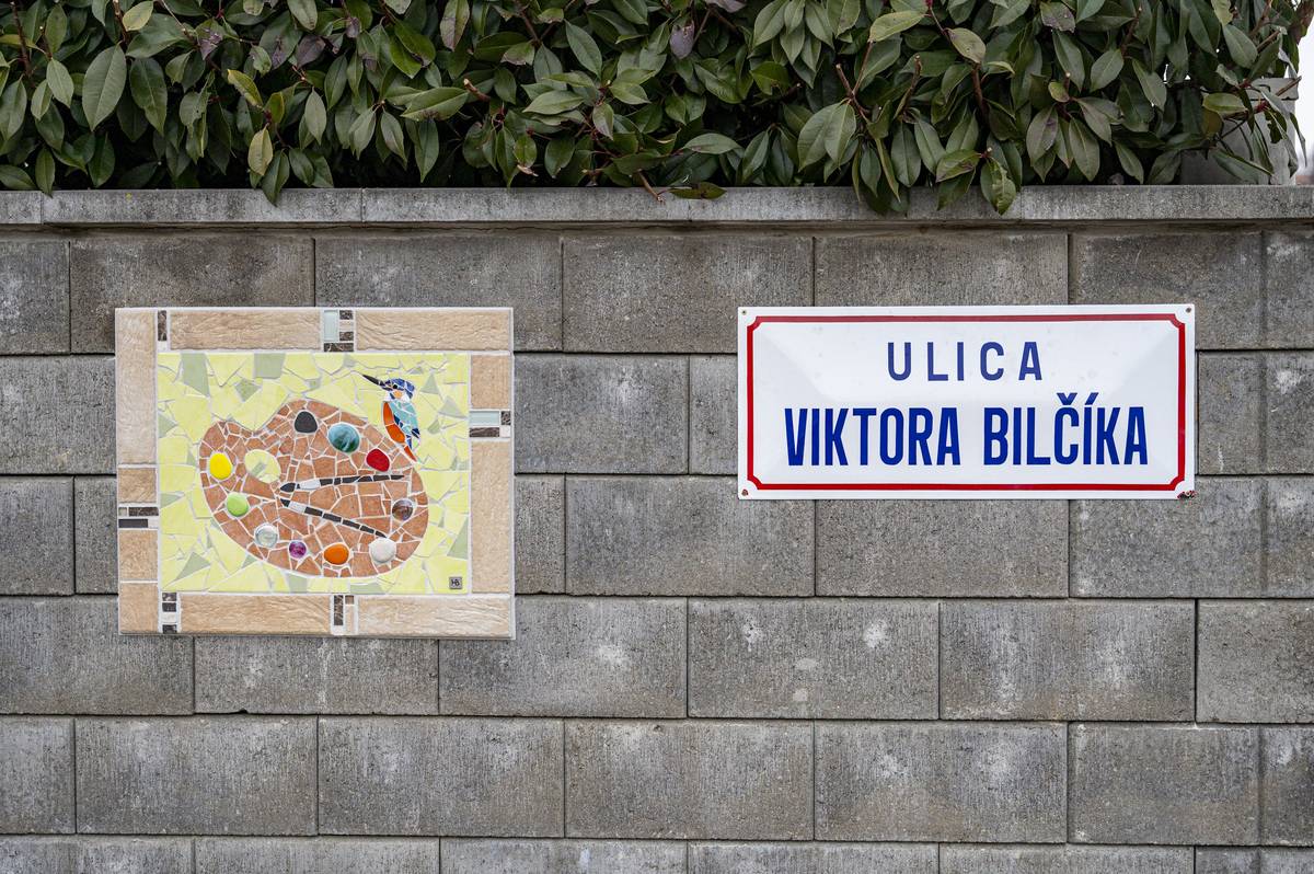 Niektoré ulice sú len miestom, ktorým prechádzame. A niektoré v sebe nesú príbeh. Ulica Viktora Bilčíka v Novom Meste nad Váhom dnes patrí k tým druhým.     Dcéra akademického maliara a reštaurátora Viktora Bilčíka sa nedávno podelila o silný a dojímavý príbeh svojho otca, ktorého ešte za života mnohí poznali pod prezývkou „Poľovník s paletou“. Nie náhodou. Miloval prírodu, z ktorej čerpal námety pre svoje obrazy, a hoci bol poľovníkom, jeho „zbraňou“ boli vždy štetce .   Viktor Bilčík sa narodil v Novom Meste nad Váhom. Neskôr sa oženil a presťahoval do Bratislavy, kde v podkroví rodinného domu vznikol jeho útulný ateliér – miesto ticha, farieb a sústredenia. Práve tam ako malé dievčatko jeho dcéra nasávala atmosféru tvorby, vôňu olejových farieb a s úžasom sledovala jemnosť, s akou jej otec nanášal každý detail na plátno. Spomienky, ktoré v nej zanechali pocit, že detstvo môže byť rozprávkové.     Keď sa dcéra Barbora "Borka" Hurajová dozvedela, že v rodnom meste jej otca bola na jeho počesť pomenovaná ulica, rozhodla sa zanechať na nej osobnú a trvalú spomienku. Vytvorila mozaiku – nie ako repliku jeho diel, ale ako symbol toho, čo mal rád. Paletu s farbami, štetce a na palete sediaceho jeho obľúbeného vtáčika – rybárika.    Mozaika bola hotová už dlhší čas, no realizácia si vyžiadala aj vnútornú odvahu a návrat na miesto, kde sa príbeh začal. Dnes je už hotová a umiestnená hneď na začiatku ulice. Vďaka patrí aj pani domácej, ktorá dovolila, aby bola nalepená na jej múriku.     Na Ulici Viktora Bilčíka tak dnes nájdeme nielen názov na tabuľke, ale aj príbeh otca a dcéry, príbeh lásky k umeniu, prírode a rodnému mestu. Malý detail, ktorý premieňa obyčajnú ulicu na miesto so zastavením.     A možno práve táto neobyčajne obyčajná ulica vyčarí okoloidúcim úsmev na tvári – tichý, nenápadný, ale úprimný. Taký, aký by si Viktor Bilčík určite želal.   Nové Mesto nad Váhom, 26.1.2026/JK   Ulica Viktora Bilčíka má nový tichý príbeh | www.nove-mesto.sk