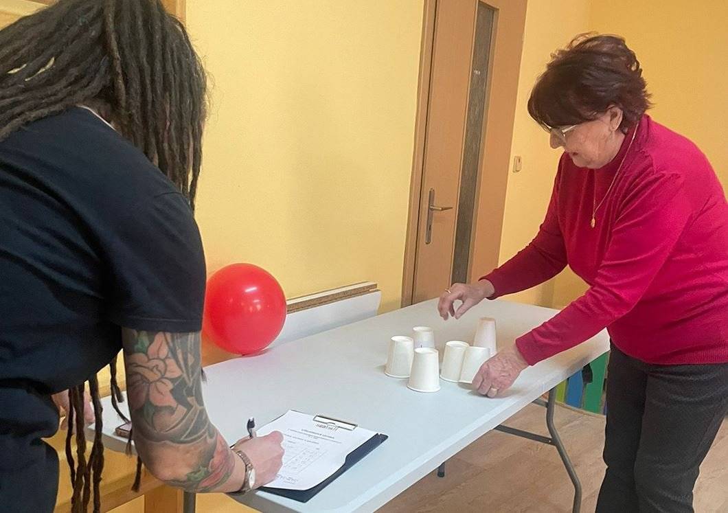 V Senior pointu Hodiny H se uskutečnil již 2. ročník Zimní olympiády pro seniory, který přinesl účastníkům spoustu radosti, smíchu a přátelské atmosféry. Dopoledne bylo plné zábavných a netradičních disciplín, které prověřily šikovnost, soustředění i smysl pro humor. Senioři si mohli vyzkoušet například házení pingpongového míčku do plata od vajíček, přenášení těstovin z plechu do mísy pomocí naběračky se zavázanýma očima, rolování toaletního papíru s malým zvířátkem nebo další originální úkoly. Nešlo o výkon, ale především o radost z pohybu, společného setkání a sdílení zážitků. Na organizaci akce se podíleli pracovníci Hodiny H společně se zahraničními dobrovolníky zapojenými do programu Evropský sbor solidarity, kteří pomáhali s přípravou stanovišť i samotným průběhem soutěží. Díky jejich zapojení měla olympiáda i mezinárodní a komunitní rozměr. „Na závěr byli vyhlášeni tři nejlepší soutěžící, kteří si odnesli krásné ceny. Všichni účastníci navíc obdrželi kalendář od Kraje Vysočina jako milou památku na společně strávené dopoledne. Zimní olympiáda pro seniory opět potvrdila, že věk není překážkou pro aktivní zapojení, zábavu a radost ze společných aktivit, a stala se příjemným zpestřením zimních dnů,“ uvedla za pořadatele akce Eva Havlíčková. Zdroj: Hodina H