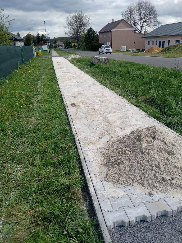 Zaměstnanci obce položili část nového chodníku v Okořínské ulici.