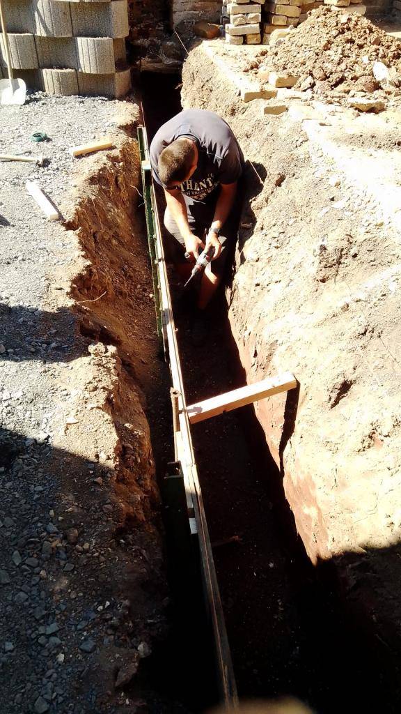 Zaměstnanci obce opravují kůlny ve školním dvoře.