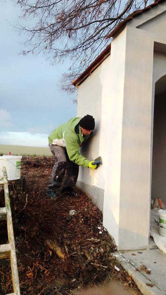 Zaměstnanci obce při opravě kapličky.