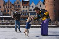 Žena si hraje se psem na zamrzlé řece Motławě v polském Gdaňsku