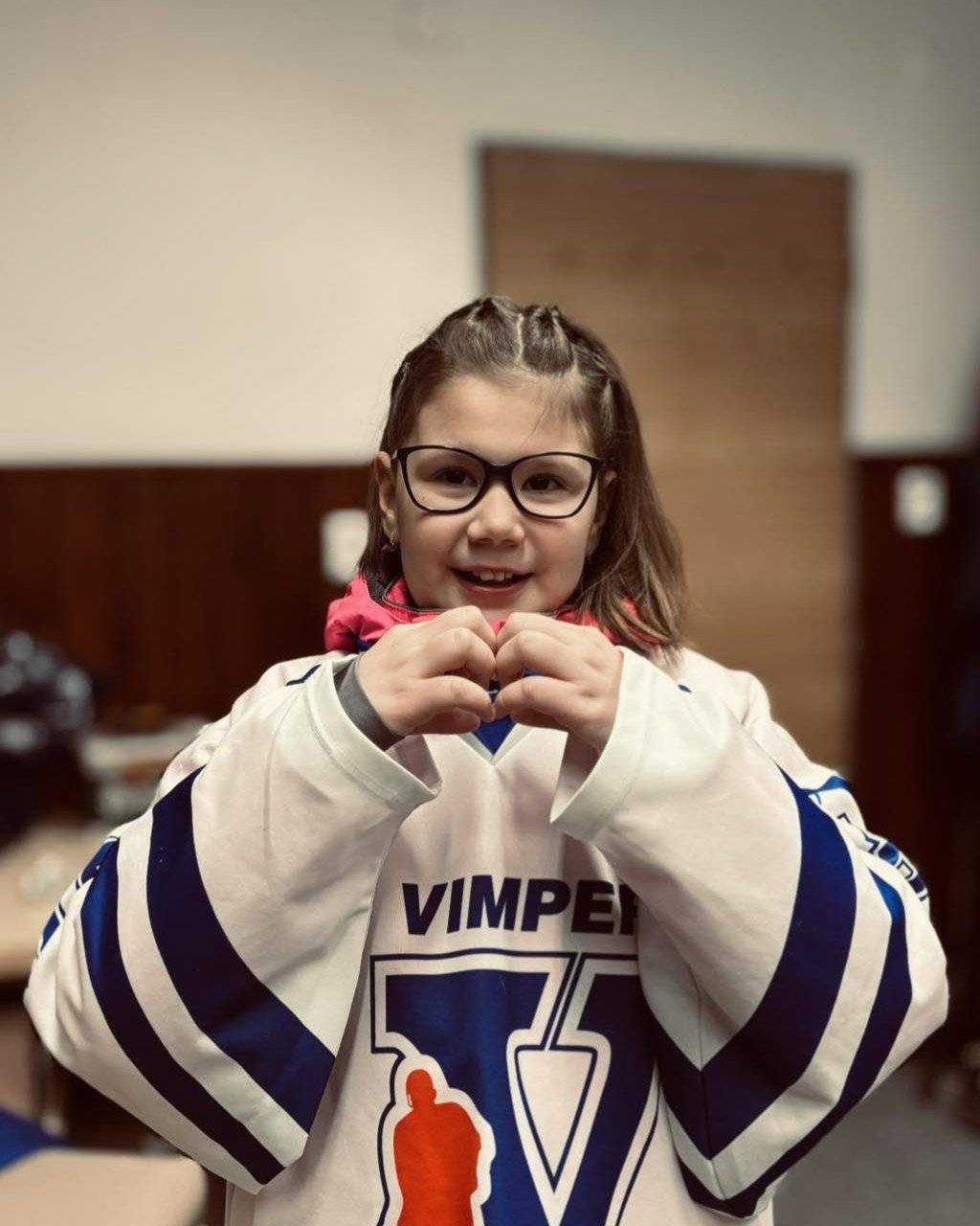 V sobotu 7. února 2026 hostil vimperský zimní stadion hokejovou benefici Happy Cup, kterou zaštítil místní rodák Šimon Hrubec. Ten také do rodného města přivezl ukázat svou unikátní sbírku pohárů za vítězství v české extralize, národní švýcarské lize a hokejové Lize mistrů. Na pomoc Elišce Malé se vybralo 300 tisíc korun! Díky, Vímperáci! Více se charitativním hokejovém zápase dozvíte v reportáži Prachatického deníku: Happy Cup ve Vimperku byl pro mě plný vzpomínek, svěřil se Šimon Hrubec - Prachatický deník Dovolujeme si také ocitovat poděkování maminky Elišky Malé, které zaslala HC Vimperk: Dobrý den všem, chtěla bych vám z celého srdce poděkovat za to, co se tady 7. února ve Vimperku na zimním stadionu odehrálo. Byl to pro nás neuvěřitelně silný a dojemný den. Nejenže jsme viděli krásný hokejový zápas a úžasné krasobruslařské vystoupení, které jsem poprvé viděla naživo… ale především šlo o naši prvorozenou Prvosenkovou dcerku Elišku. Naši hokejisté se pro ni spojili se Šimonem Hrubcem, Saves Help, Happy Cupem a nadací Dobrý skutek. A hlavně se spojili s vámi. S lidmi, kteří přišli osobně, i s těmi, kteří pomohli jinak. Najednou tu bylo tolik dobra a podpory, že se to ani nedá popsat slovy. Za celou naši rodinu vám chci opravdu z celého srdce poděkovat. Vybraná částka je pro nás obrovská a neuvěřitelná. Ale ještě důležitější je to, co znamená pro naši Elišku – naději a jistotu do budoucna. Penízky zůstanou v nadaci, která bude Elince postupně pomáhat hradit vše, co bude potřebovat. Ještě teď v únoru k nám přijede fyzioterapeutka, aby se s Eliškou seznámila. Věříme, že v domácím prostředí se bude cítit bezpečně a že bude ochotná spolupracovat. Každý její malý pokrok je pro nás obrovskou radostí. Chtěla bych také extra moc poděkovat celému Vimperskému hokejovému klubu HC Vimperk. Pro Elišku vytvořili krásné, klidné a laskavé prostředí. Díky nim byla spokojená, bez stresu a mohla být součástí téhle akce. Můj největší strach byl, že by na led vůbec nešla – a díky vám ten strach zmizel. A na závěr bych chtěla říct jednu věc… Vimperk a jeho okolí může být opravdu hrdé. Má kolem sebe lidi s obrovským srdcem, kteří umí držet při sobě a pomáhat tam, kde je to nejvíc potřeba. Děkujeme vám za pomoc, za podporu a za naději. Děkujeme za naši Elišku