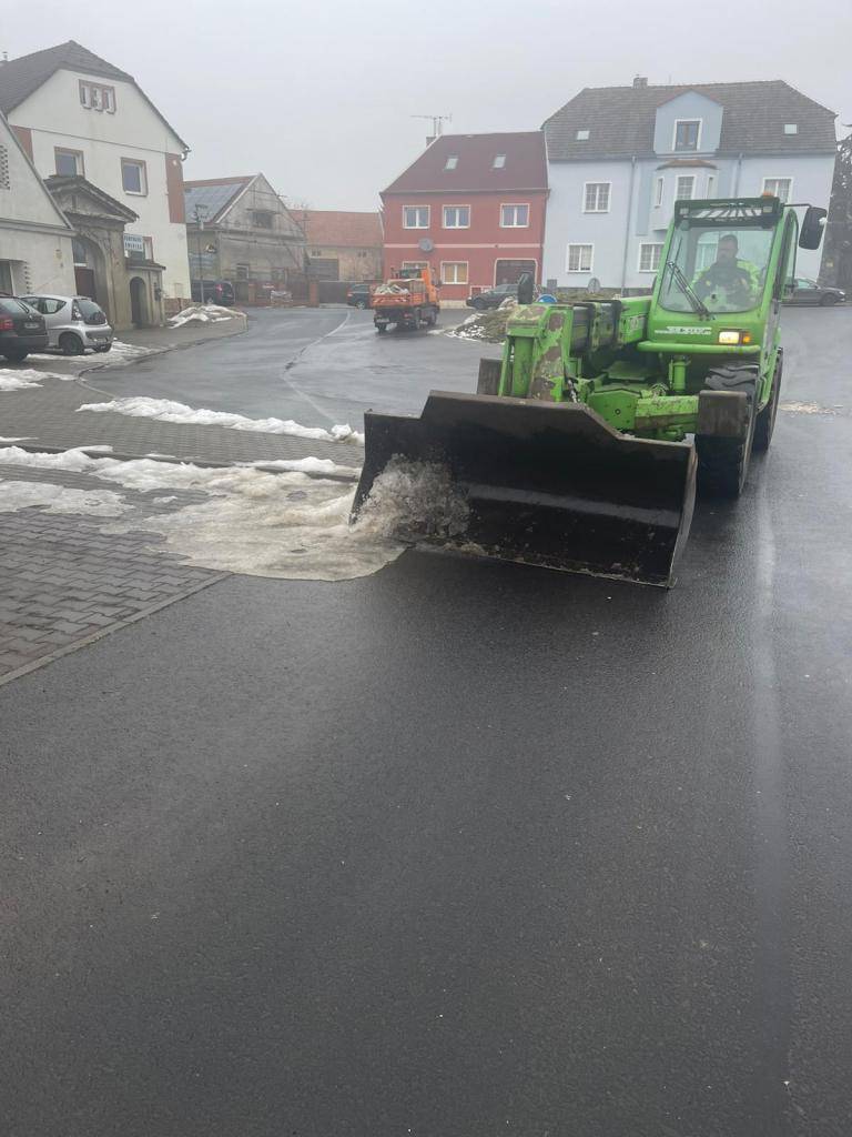 Zaměstnanci obce při úklidu zmrzlého sněhu ze silnic a chodníků.