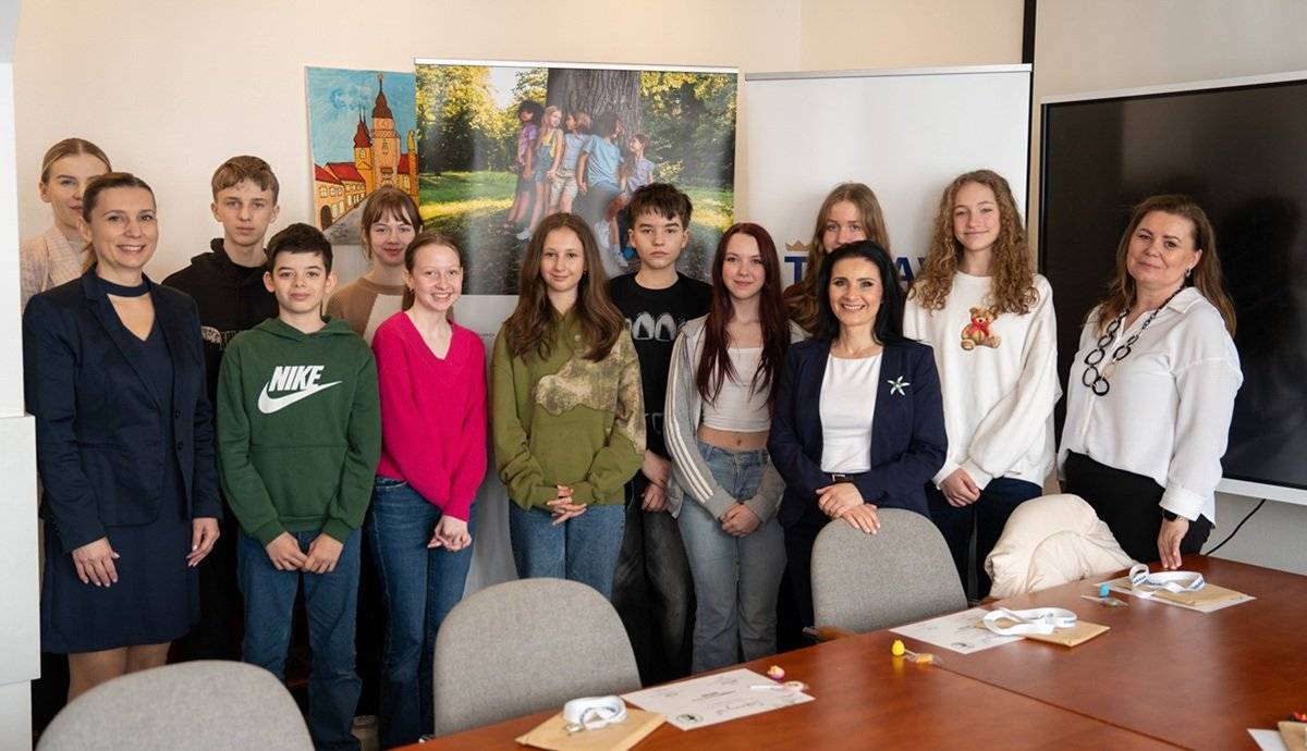 Mestský úrad v Trnave privítal v utorok 17. marca 2026 nevšednú návštevu – deti z trnavských základných škôl. V rámci kampane Bezpečné miesto realizovanej v spolupráci s koordinátorkou ochrany detí pred násilím Lenkou Kováčovou z Úradu práce, sociálnych vecí a rodiny Trnava bolo cieľom priblížiť im fungovanie mesta a ukázať, že mestský úrad je miestom, kde môžu v prípade potreby nájsť pomoc a podporu. Počas návštevy sa deti oboznámili s činnosťou samosprávy a fungovaním odboru sociálnych vecí. Priestormi úradu ich previedla jeho vedúca Marcela Sedláková, ktorá im zrozumiteľne vysvetlila, ako mesto pomáha obyvateľom v rôznych životných situáciách a kedy sa môžu na mestský úrad obrátiť. Súčasťou programu bola aj diskusia s viceprimátorkou Evou Nemčovskou, ktorá deťom priblížila oblasti školstva, kultúry a bezpečnosti v meste. Dôležitým momentom návštevy bolo symbolické označenie budovy mestského úradu na Trhovej 3 nálepkou kampane Bezpečné miesto, umiestnenou na vstupných dverách. Tento krok vysiela jasný odkaz, že mestský úrad je bezpečným bodom, kde deti môžu nájsť pomoc, podporu a pochopenie. „Deti sa počas celého stretnutia aktívne zapájali, kládli nám zaujímavé otázky a na záver sa podelili o svoje dojmy. Ich pozitívna spätná väzba potvrdila, že takéto aktivity majú význam, pretože pomáhajú budovať dôveru medzi mladými ľuďmi a verejnými inštitúciami,“ uviedla M. Sedláková. Mesto plánuje v podobných aktivitách pokračovať aj naďalej, aby deti vedeli, že v prípade potreby sa majú na koho obrátiť.