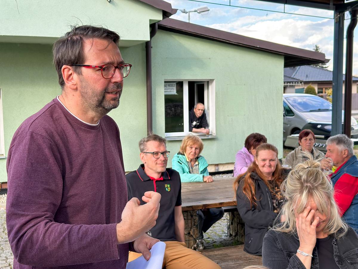 CHODOV (20. 4. 2026) - Intenzivnější a cílenější komunikace přes aplikaci Munipolis, nový chodník či oprava nedalekého mostu byla témata, která se probírala na pravidelném setkání vedení Chodova s obyvateli Staré Chodovské. To se tentokrát uskutečnilo pod širým nebem ve společenském zázemí u hřiště, které spravuje spolek Sport a kultura Stará Chodovská, z. s. Dorazily na něj zhruba dvě desítky místních. Hned v úvodu starosta Patrik Pizinger ujistil přítomné, že záměr dočasné skládky energosádrovce definitivně padl. Následná diskuse se zaměřila především na dopravní infrastrukturu a informovanost obyvatel, včetně plánů na využití aplikace Munipolis pro rychlejší a přehlednější komunikaci s veřejností. Jedním z bodů byl nový chodník, který má zvýšit bezpečnost v okolí hřiště. „Na chodník je už vydané povolení a s jeho stavbou se začne v příštím roce,“ uvedl starosta s tím, že povede po levé straně komunikace. Obyvatelé se zajímali také o připravovanou opravu nedalekého mostu, která si vyžádá dočasné omezení a zvýšení provozu na hlavním tahu obcí. Řeč se vedla také o návrhu jízdního řádu uvažované městské hromadné dopravy v Chodově. Setkání, kde nechybělo drobné občerstvení, proběhlo v pohodové atmosféře, do diskuse se vedle starosty zapojil také místostarosta Chodova Luděk Soukup. Podle vedení města budou podobná setkání pokračovat i nadále, aby měli obyvatelé možnost přímo ovlivňovat dění ve svém okolí.