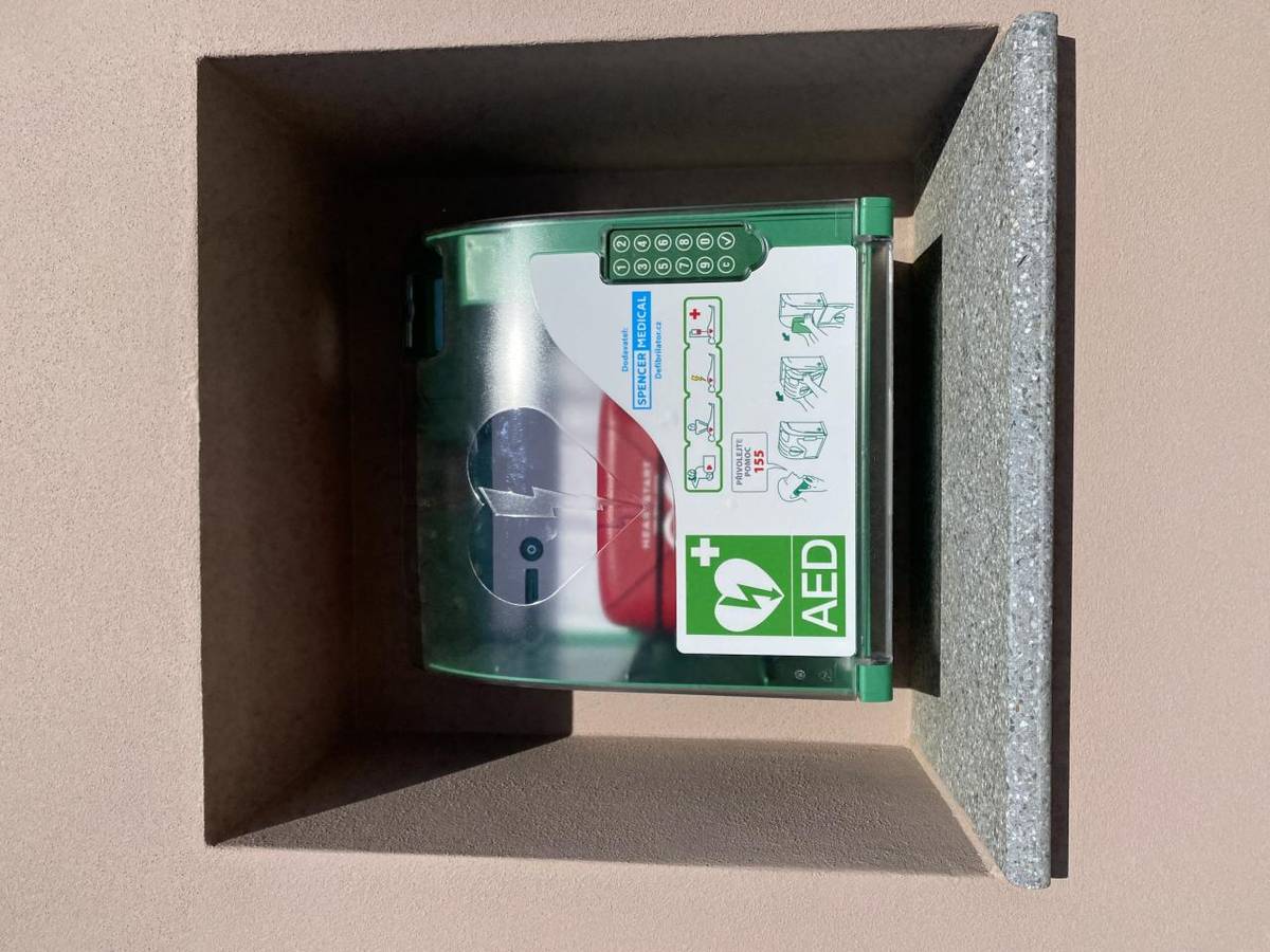 Na budově na křižovatce je nově umístěn automatizovaný externí defibrilátor (AED). Je tu pro nás všechny a připraven zachránit život.