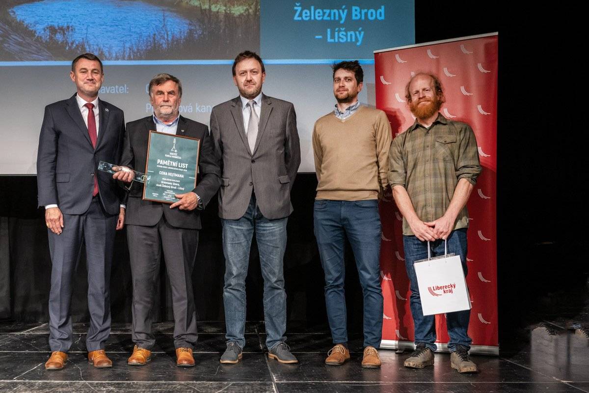 Ve čtvrtek 14. května 2026 proběhl 22. ročník Soutěže Karla Hubáčka – Stavba roku Libereckého kraje. Do letošního ročníku soutěže se přihlásilo celkem 25 staveb a sedm studentských projektů. Porota většinu staveb osobně navštívila a při hodnocení sledovala nejen architektonickou a stavební kvalitu, ale také dopad projektů na okolí, veřejný prostor nebo kvalitu života obyvatel. Titul absolutního vítěze 22. ročníku Soutěže Karla Hubáčka – Stavba roku Libereckého kraje získal projekt Muzeum veteránů Turnov. Uspěl však i Železný Brod, který získal nominaci v kategorii Veřejný prostor, voda a krajina za část cyklostezky Greenway Jizera v úseku Železný Brod – Líšný. V dané kategorii nakonec zvítězila rekonstrukce veřejného prostranství v okolí budovy krajského úřadu Libereckého kraje – Liberecká náplavka. Cyklostezka Greenway Jizera v úseku Železný Brod – Líšný však získala Cenu hejtmana Libereckého kraje. Stavba dle odborné poroty přispěla k oživení turistického ruchu ve městě a zároveň k podpoře využívání alternativních způsobů dopravy samotných obyvatel Železného Brodu a okolí. O cenu Karla Hubáčka soutěžila ještě i jiná stavba v Železném Brodě, a to lávka přes Jizeru. Ta se však na předních příčkách k naší velké lítosti neumístila. Vítězové všech kategorií získali originální skleněnou vodováhu, autorskou cenu navrženou studentem umělecké sklářské školy v Železném Brodě Romanem Marešem. Ceny opět pro Soutěž Karla Hubáčka vyrobila sama sklářská škola. Jsme rádi, že se tak jedna ze skleněných vodováh dostala zpátky do Železného Brodu.