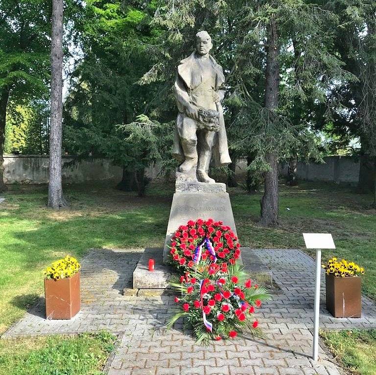 V centru Vinoře, v parku před hřbitovem, stojí od roku 1949 pískovcová socha rudoarmějce. Jedná se o celkem umělecky hodnotné dílo a zároveň o připomínku konce druhé světové války a role Rudé armády při osvobození Prahy. Místo mělo původně i pietní charakter – byly zde uloženy ostatky pěti vojáků, kteří zahynuli až po konci války. Ty byly později exhumovány, a ještě před instalací sochy přeneseny na centrální vojenské pohřebiště v Praze, na Olšanské hřbitovy. Městská část Praha-Vinoř si této sochy dlouhodobě váží a přistupuje k ní jako k historickému i kulturnímu artefaktu. Právě proto jsme nemohli zůstat nečinní v situaci, kdy je socha opakovaně ničena. V posledních desetiletích se bohužel nejednou stala terčem vandalismu. Již v roce 1968 byl uražen samopal, v 90. letech zmizela bronzová pamětní deska se jmény. V posledních letech pak útoky zesílily – socha byla polita červenou barvou a na konci roku 2025 došlo k nejzávažnějšímu poškození, kdy byla uražena a odcizena celá hlava. Spolu s tím byla zničena i druhá pamětní deska. Zároveň pískovec na dešti a slunci za osmdesát let výrazně zvětral a na mnoha místech se drolí jen při lehkém doteku. Pozoruhodná je i skutečnost, že aktuálně není zcela jasné, komu socha vlastně patří. Městská část Praha-Vinoř ji ve svém soupisu majetku nemá. Samotný pozemek je ve vlastnictví římskokatolické církve, ale ani ta sochu ve svém majetku neeviduje a k jejímu vlastnictví se nehlásí. Snažíme se nyní v součinnosti s vlastníkem pozemku a dalšími institucemi zjistit, kdo by měl být vlastník sochy, respektive zda sochu může Městská část Praha-Vinoř přibrat do svého majetku, jako to nedávno udělala se sochou svatého Jana Nepomuckého na Vinořském náměstí, která také neměla jasného majitele. Městská část se tématu sochy aktivně věnuje. Opakovaně jsme spolupracovali s Policií ČR, žádali zvýšený dohled městské policie, a především jsme oslovili šestnáct odborných institucí – muzea, galerie, paměťové organizace, státní orgány i velvyslanectví Ruské federace – s cílem najít dlouhodobě udržitelné řešení. Obáváme se totiž toho, že pokud by se investovaly stovky tisíc do opravy sochy, reálně hrozí riziko, že sochu někdo opět poškodí, či zcela zničí, jako se to stalo loni podobné soše v Teplicích nebo Litoměřicích, či dříve v Přibyslavi a Jaroměři. Ve většině získaných doporučení oslovených institucí se objevuje podobné stanovisko: pokud má být socha zachována, je nutné ji přemístit do chráněného prostředí a teprve následně řešit její odbornou renovaci a obnovu. Naším cílem není sochu odstranit nebo znehodnotit její význam. Chceme ji jako hodnotné dílo ochránit. Jedinou realistickou cestou, jak toho dosáhnout, je její přemístění do bezpečného a důstojného prostředí respektované instituce, kde bude chráněna před nepřízní počasí, vandalismem a kde může být časem i odborně restaurována. Považujeme i za důležité zachovat historickou paměť tohoto místa. Proto pracujeme na řešení, kdy by na současném stanovišti vznikla nová pamětní deska, připomínající jak původní sochu, tak události druhé světové války i pietní charakter lokality. Chceme jasně říci, že tento postup není motivován ideologicky ani snahou cokoliv „odstraňovat“ nebo přepisovat historii. Naopak vychází z odpovědnosti a snahy zabránit definitivnímu zničení sochy. Zkušenosti z jiných měst bohužel ukazují, kam může neřešený stav vést. V Teplicích byla socha rudoarmějce v květnu 2025, po opakovaném poškozování vandaly, v noci stržena z podstavce a po dopadu se rozbila na kusy, bez jakékoli šance na opravu. Věříme, že se nám ve spolupráci s vlastníkem pozemku i odbornými institucemi podaří najít řešení, které umožní sochu zachovat pro budoucí generace – nikol