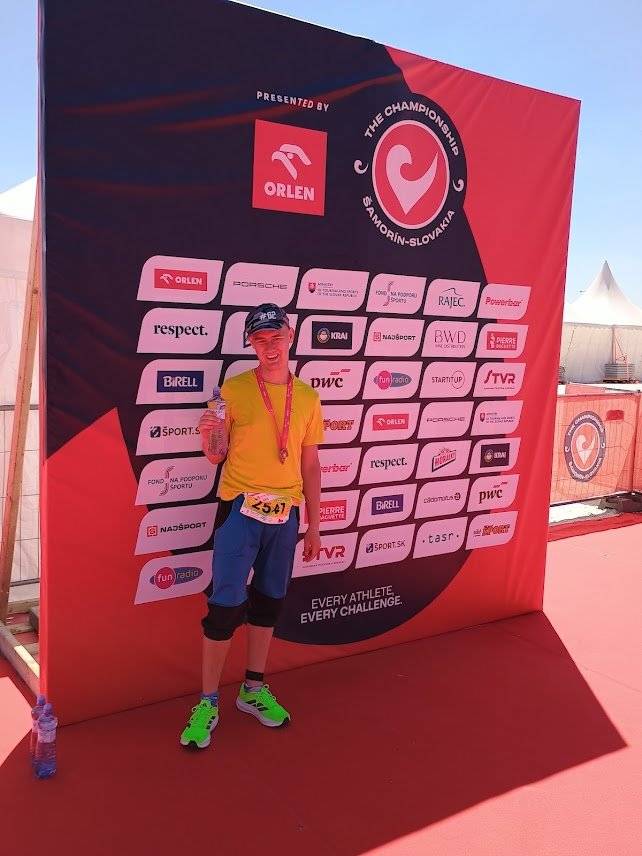 Velkého úspěchu dosáhl český reprezentant a žacléřák Filip Ruffer, který se zúčastnil prestižního závodu 5th Special Olympics European Open Triathlon Competition, konaného ve dnech 21. – 25. května 2026 v slovenském Šamoríně. Závody probíhaly v areálu x-bionic sphere, kde sídlí slovenské olympijské tréninkové centrum, a byly součástí finále světové série triatlonových závodů Challenge Family. Do závodu nastoupili sportovci ze Slovenska, USA, Izraele, Estonska, Monaka, Maďarska, Finska, Česka a Německa. Filip Ruffer, závodící za tým Kladiva Žacléř, předvedl ve velmi silné konkurenci výborný výkon a v kategorii B obsadil skvělé 4. místo. Zároveň se stal vůbec prvním Čechem, který tento náročný triatlon Speciálních olympiád dokončil. Triatlon zahrnoval plavání, cyklistiku i běh a prověřil fyzickou i psychickou odolnost všech závodníků. Velký podíl na Filipově úspěchu má také jeho trenérka Dominika Pospíšilová, která ho na závod dlouhodobě připravovala. Filipovi gratulujeme ke skvělé reprezentaci České republiky, Žacléře i Specialní Olympiády a přejeme mu mnoho dalších sportovních úspěchů.