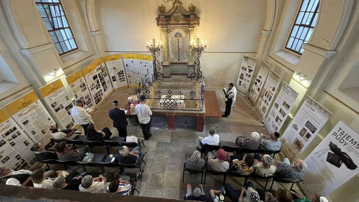 LETNÍ ŠÁBES V SYNAGOZE Ve dnech 24. a 25. července 2026 se opět po roce uskuteční židovské bohoslužby v lužské synagoze. Již popáté se zde chystá akce s názvem „letní šábes v synagoze“, které se pravidelně účastní potomci bývalých členů někdejší lužské židovské náboženské obce a jejich přátelé. Do synagogy jsou zváni všichni, kteří chtějí zažít páteční modlitbu na uvítání šabatu, po ní bohatý kiduš (hostina) s košer vínem, a v sobotu potom bohoslužbu se čtením z Tóry. Tóra bude do synagogy jako každoročně přivezena kantorem pražské židovské obce panem Danielem Vaňkem, který bohoslužbu povede. Díky této obnovené tradici se vždy jednou ročně vrací synagoga svému účelu a dochovaný vzácný klasicistní aron ha-kodeš se stává skutečnou schránou svaté Tóry.  Čtení z Tóry je vázáno na minjan, náboženské nařízení, že se musí sejít alespoň 10 dospělých židovských mužů dle halachy. Není dnes jednoduché ho dosáhnout a ani my nevíme, jestli se to povede, ale bohoslužba se v omezené podobě může konat i při jeho nenaplnění. Program začne v pátek 24. 7. v 19:30 modlitbou, pokračovat bude potom v sobotu 25. 7. v 10:00 obvyklou sobotní bohoslužbou. Zváni jsou všichni, kteří by se rádi účastnili, bez ohledu na jejich osobní náboženské vyznání, požadován je pouze respekt k odlišné tradici a vhodné oblečení. U mužů je to pokrývka hlavy (stačí obyčejná kšiltovka či klobouk). Po skončení páteční modlitby proběhne krátké povídání autorky výstavy Alžběty Langové s představením vzácných hostů, bude možnost komentované prohlídky synagogy a dotazů.