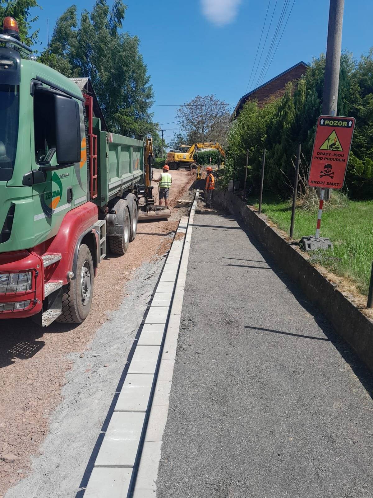 Vážení občané, podáváme Vám nové informace týkající se prací v Hronovské ulici (U Kříže). Stavební práce nabraly zpoždění oproti původnímu schválenému harmonogramu. Na stavbě se řeší nepředvídatelné práce, které ovlivnily návaznost dalších činností a zpomalily postup I. etapy. Předpokládaný termín dokončení I. etapy je nyní stanoven na 19. 06. 2026.  Ing. Jaroslava Valentová,  Údržba silnic Královéhradeckého kraje a.s. Bc. Stanislav Řezníček, DiS., starosta města