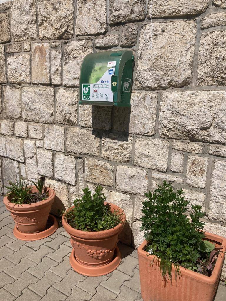 AED sa v našej obci nachádza na budove Obecného úradu. Je to prístroj, ktorý dokáže analyzovať srdcový rytmus a po jeho vyhodnotení, ak je to potrebné, podá elektrický výboj. Použitím AED do 5 minút dokážeme maximalizovať šancu na záchranu postihnutého až na 75% (www.155.sk).